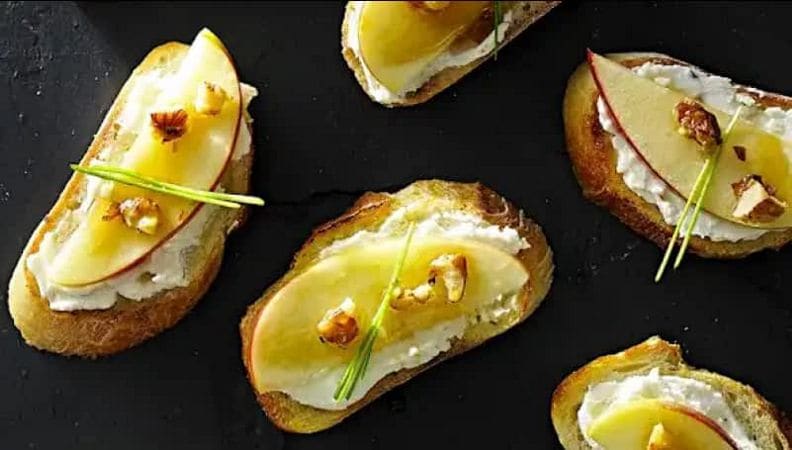 Apple brie crostinis served on a plate.
