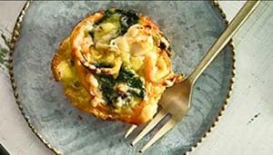 Mini sweet potato and spinach frittatas on a plate with a fork.