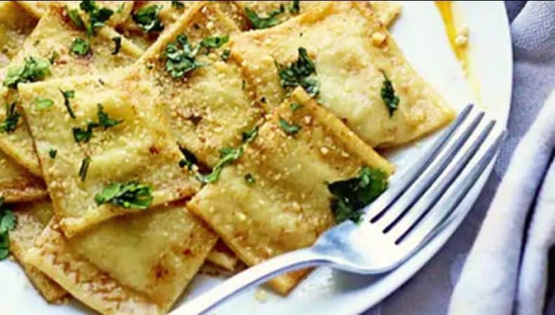Butternut squash ravioli served on a plate with a fork.