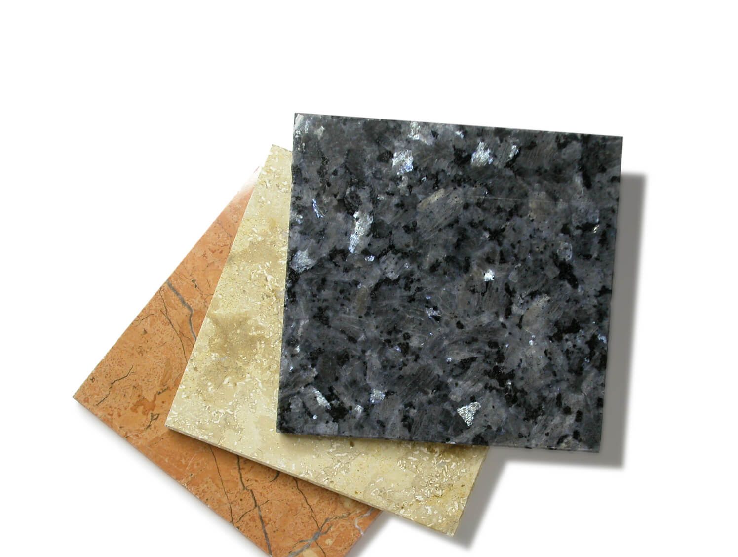 Three samples of stone for countertops including a clay, a tan and a dark grey color.