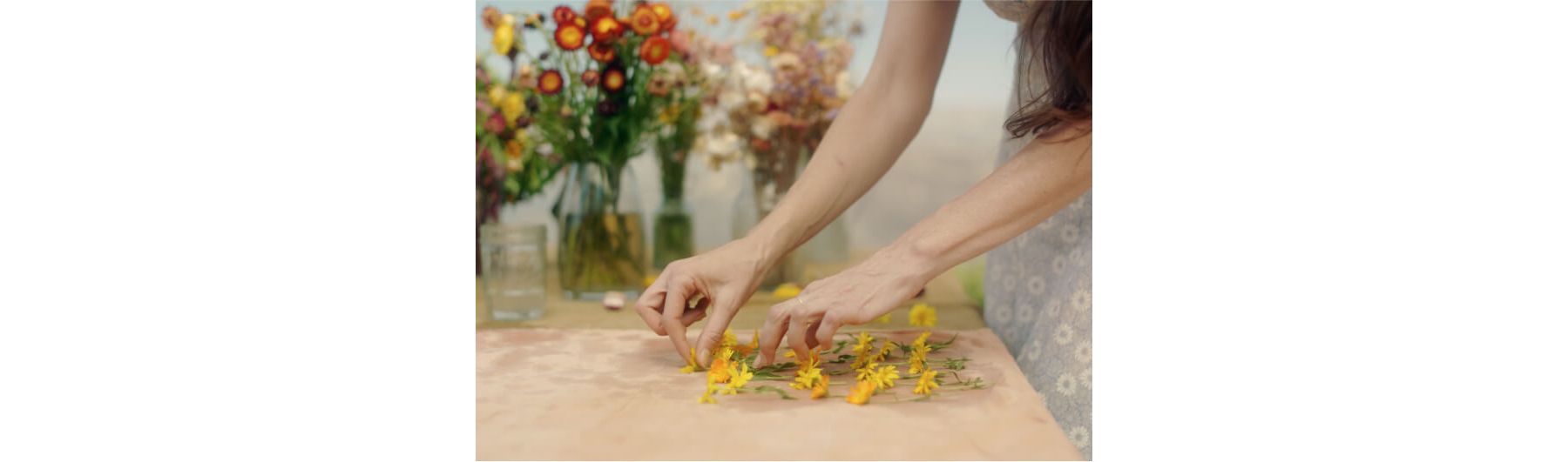 A woman arranging delicate flowers.