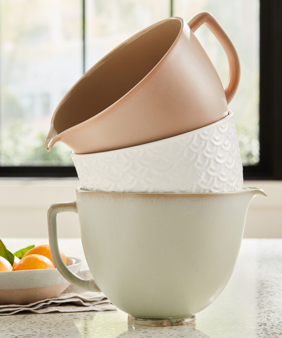 Three ceramic KitchenAid® Stand Mixer Bowls in Sage Leaf, Fired Clay and Mermaid Lace stacked together.