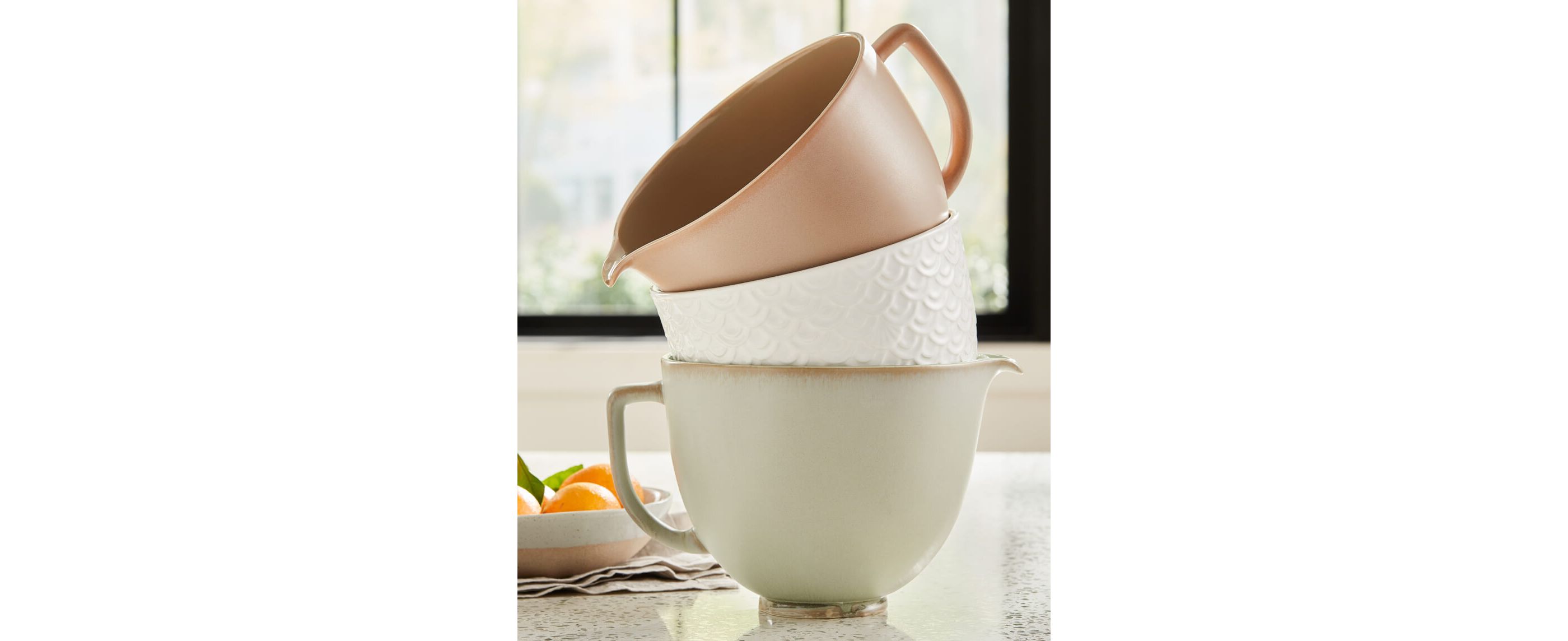 Three ceramic KitchenAid® Stand Mixer Bowls in Sage Leaf, Fired Clay and Mermaid Lace stacked together.