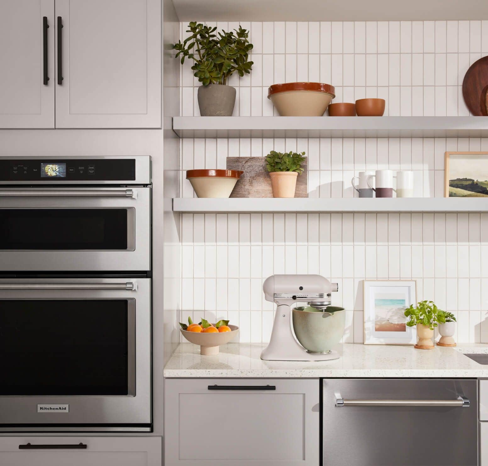 KitchenAid® Combination Wall Oven and Dishwasher in stainless with Stand Mixer on countertop.