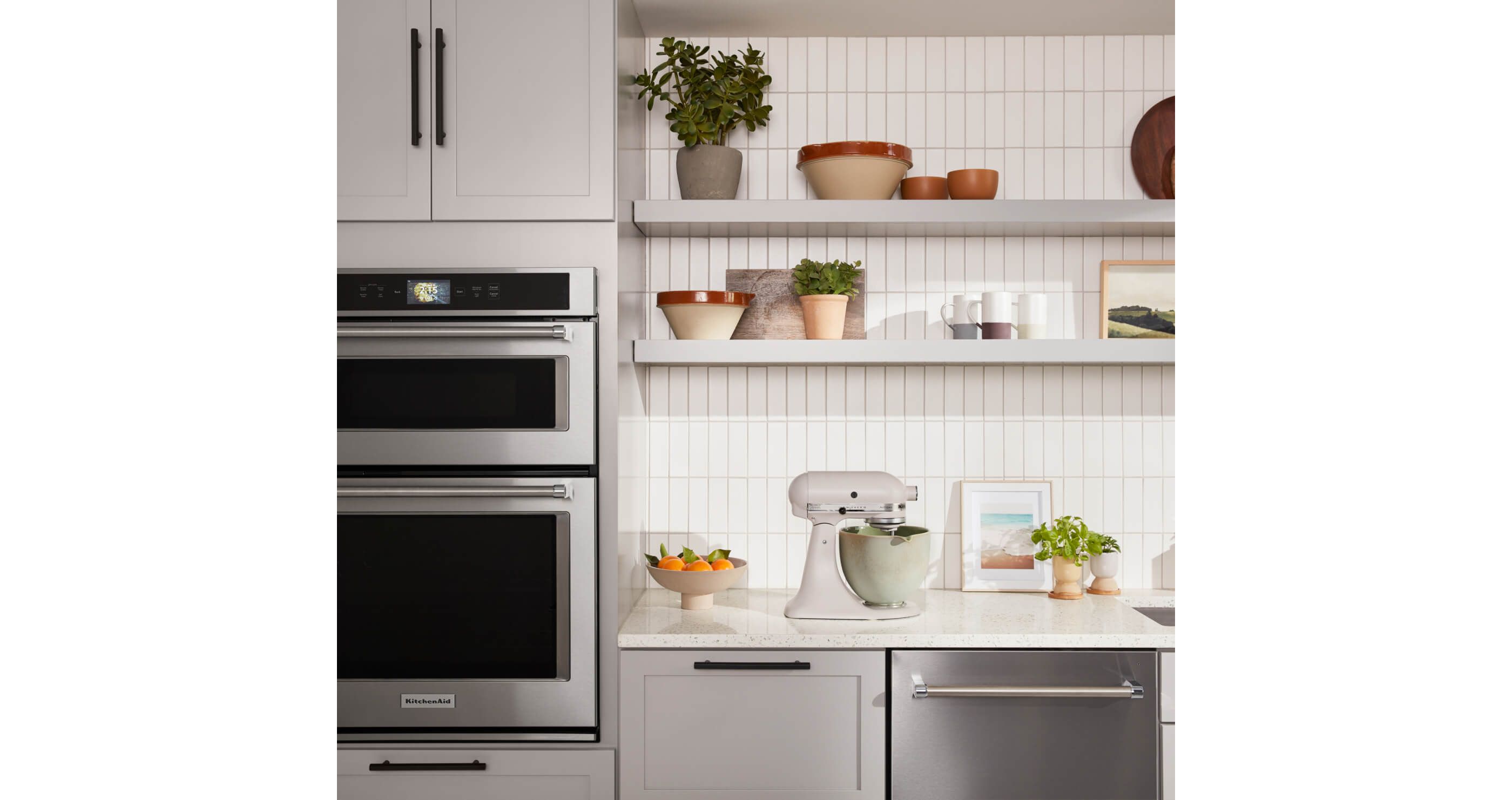 KitchenAid® Combination Wall Oven and Dishwasher in stainless with Stand Mixer on countertop.