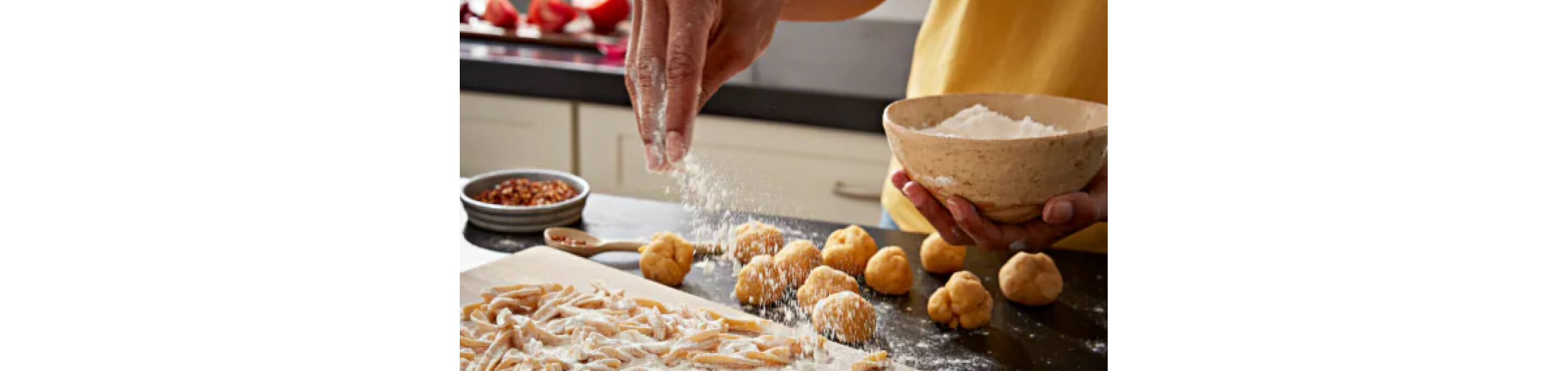 A person sprinkling flour over dough.