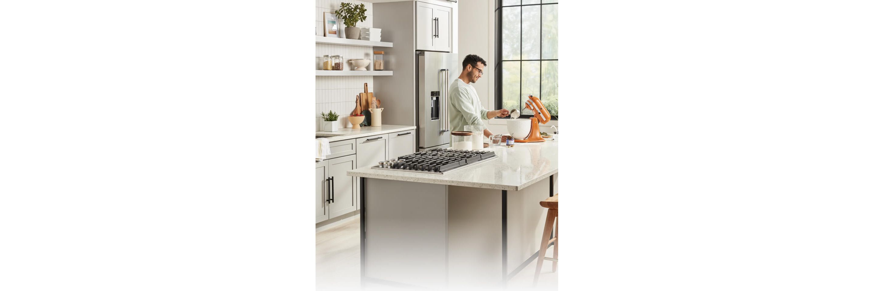 A person in a white kitchen using a KitchenAid® Stand Mixer