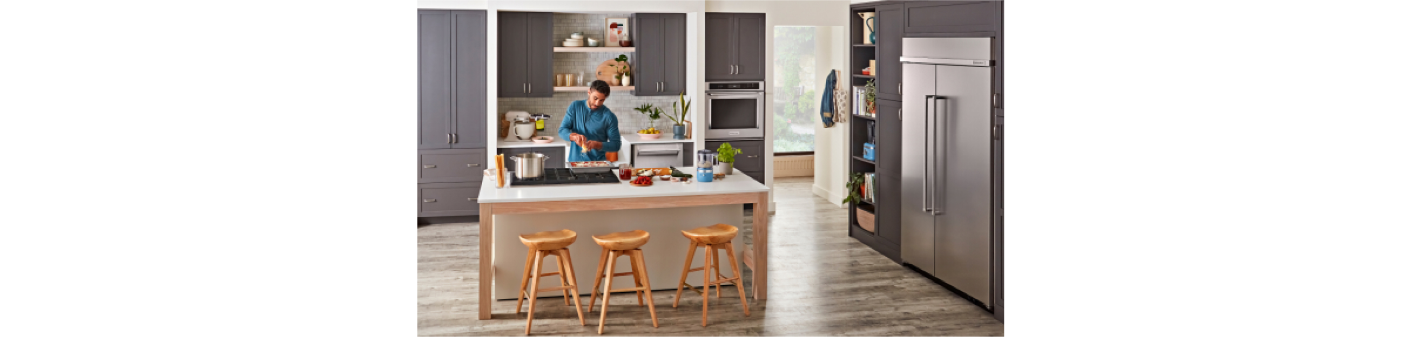 A person cooking sauce in a large modern kitchen. 