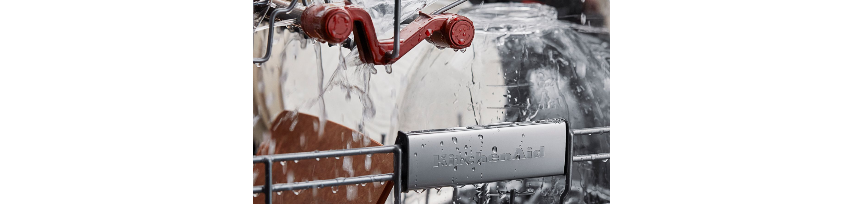 An interior shot of water flowing over dishes in a KitchenAid dishwasher.