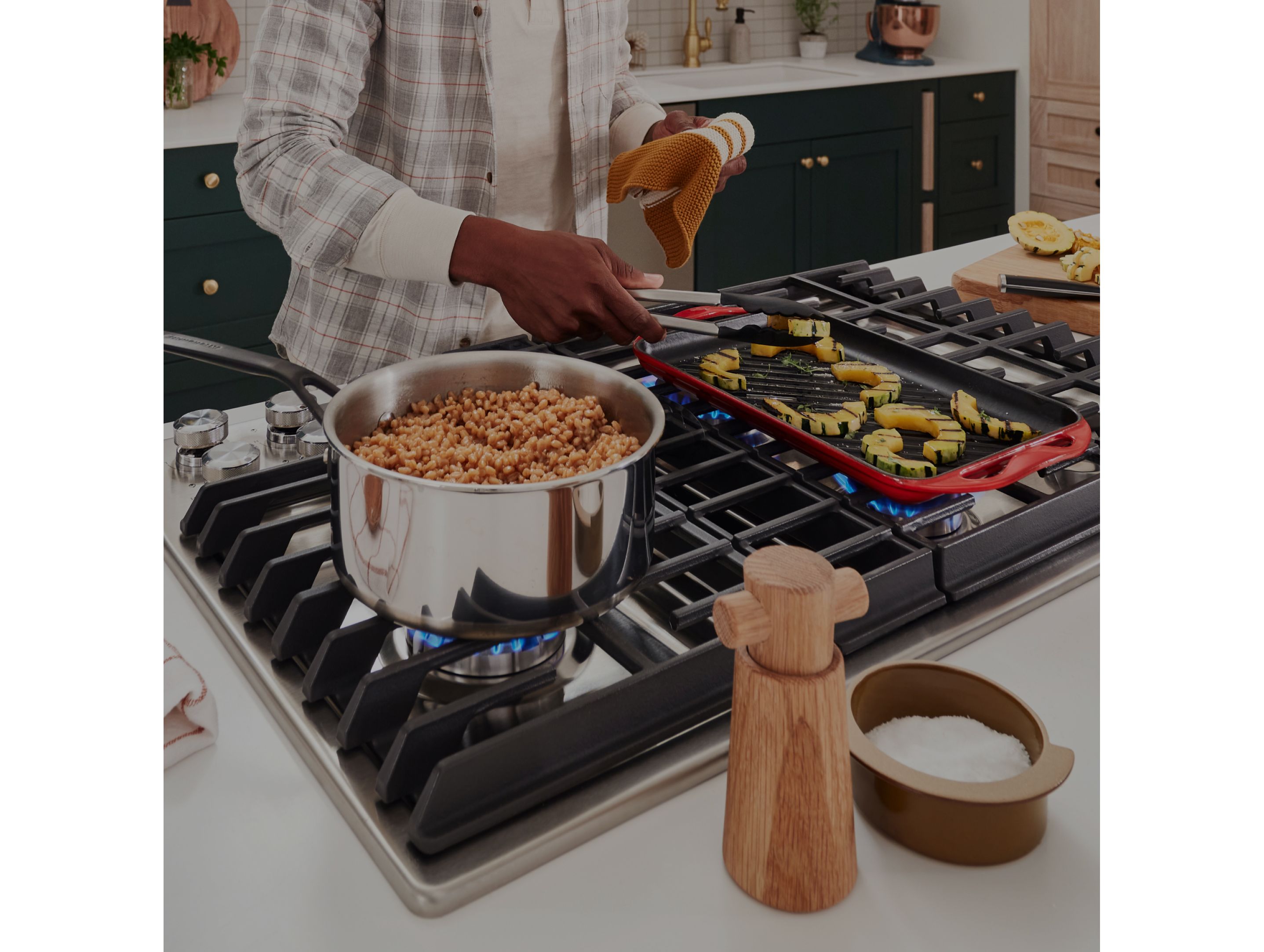 A person grilling food in a grill pan on a cooktop.