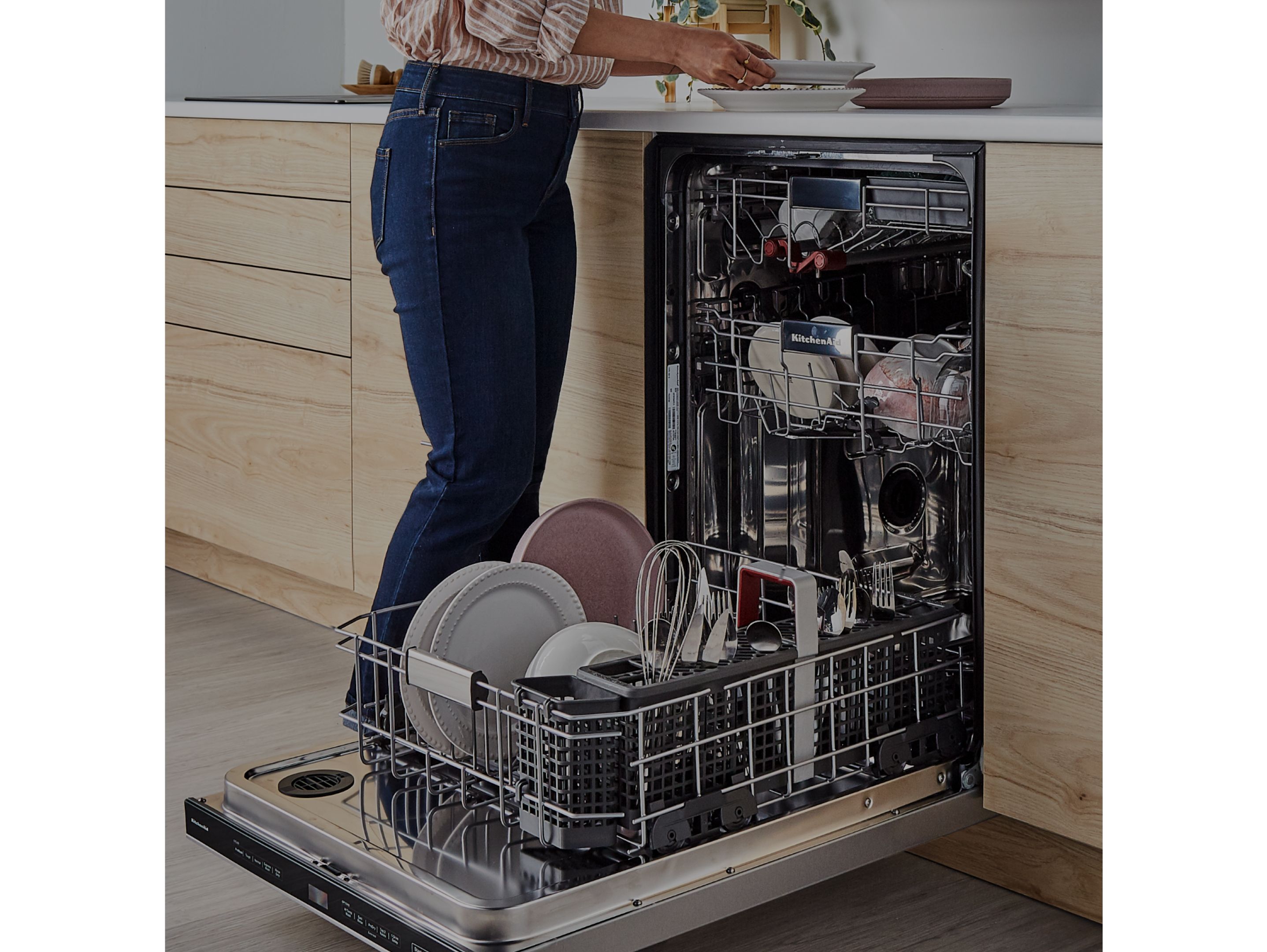 A person unloading dishes from a dishwasher.