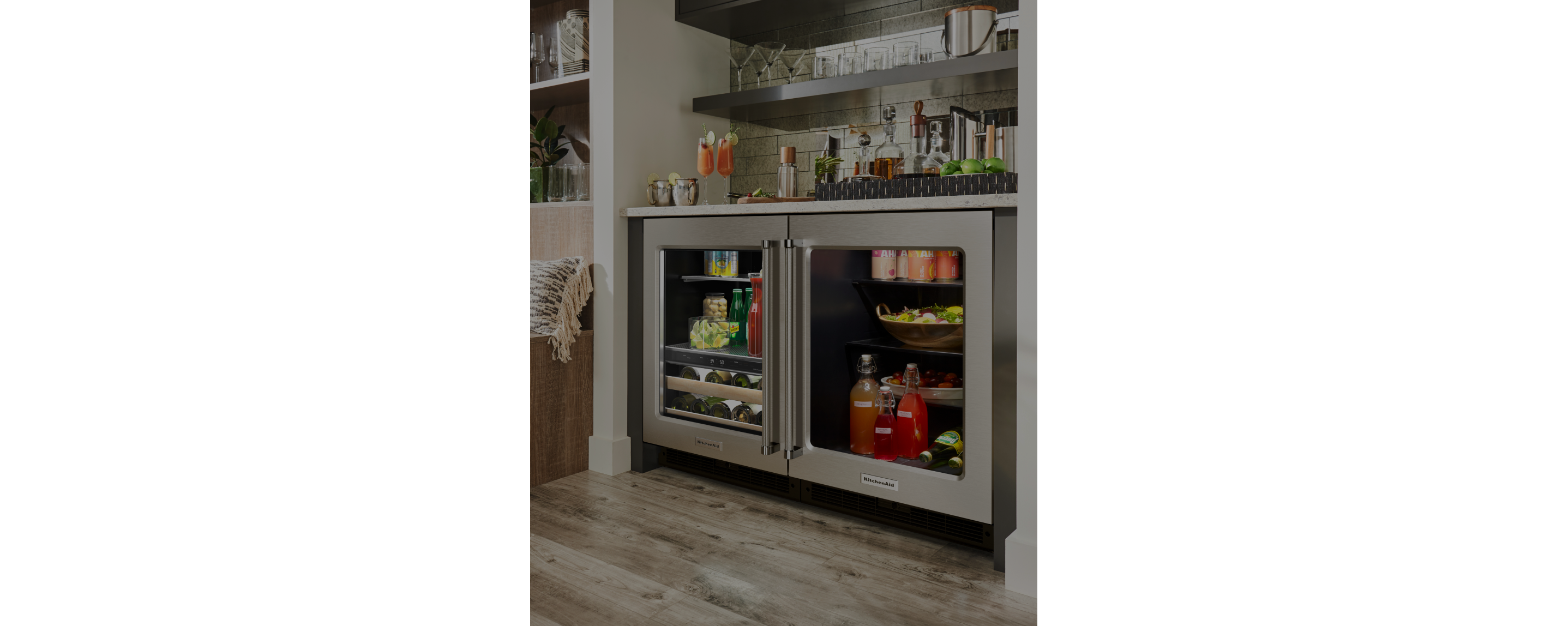 A fully stocked KitchenAid® beverage center and undercounter refrigerator installed in a wet bar.  