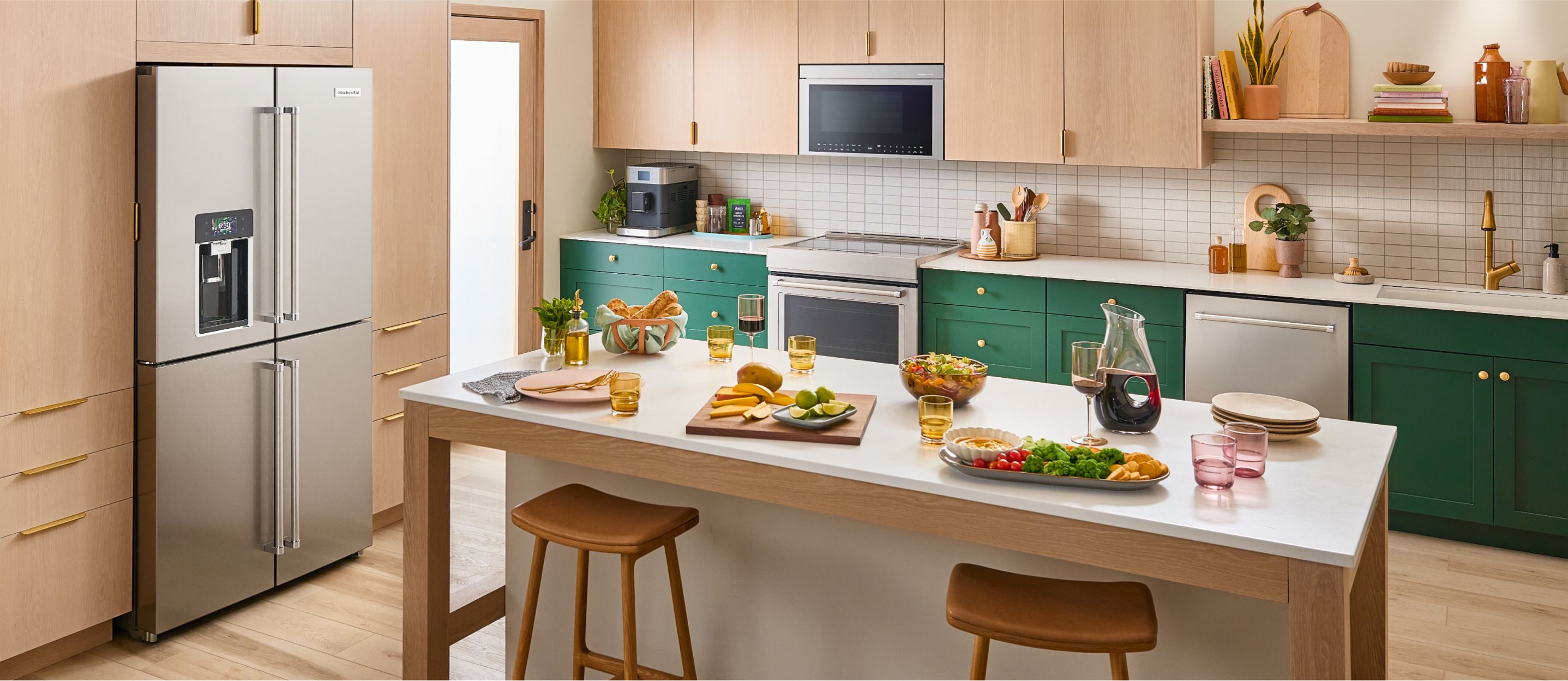 A kitchen with light cabintry and KitchenAid® appliances and food atop the counter.