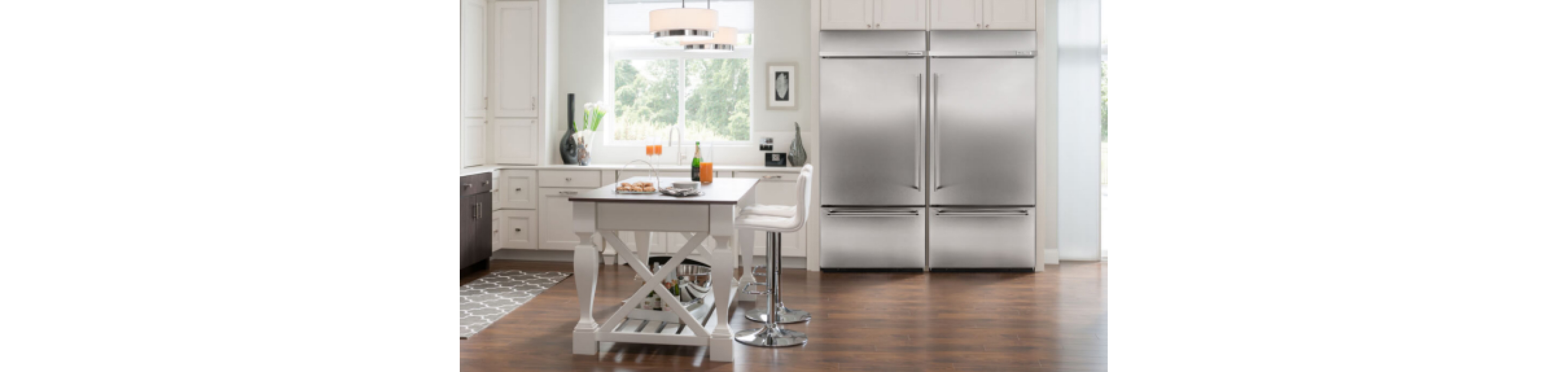 A modern kitchen with white cabinets and a large capacity KitchenAid® refrigerator.