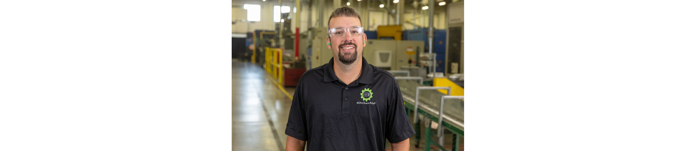 Smiling KitchenAid® employee at refurbished appliances facility.