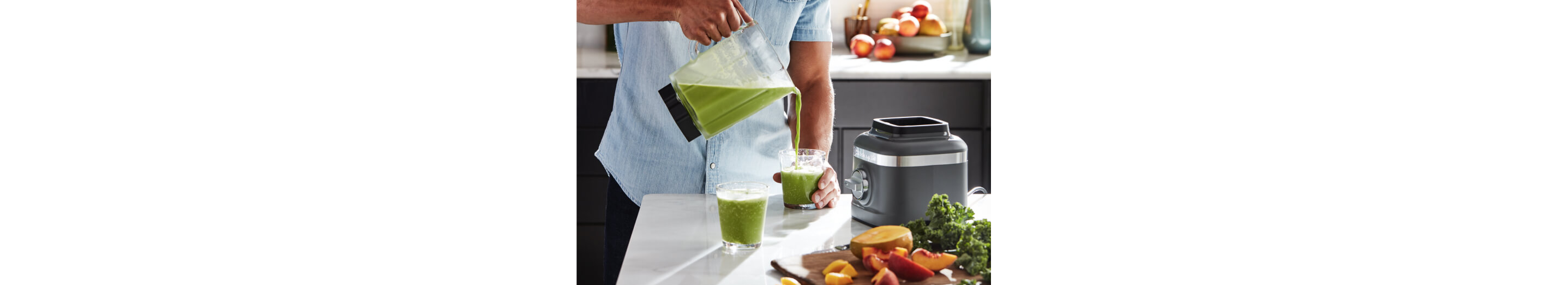 Man pouring a green smoothie from a KitchenAid® refurbished blender jar.