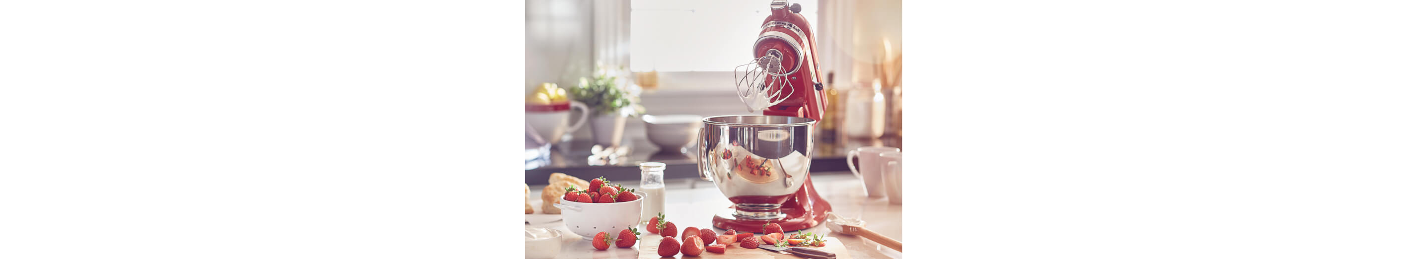 Refurbished KitchenAid® mixer with wire whip and stainless steel bowl making whipped cream.