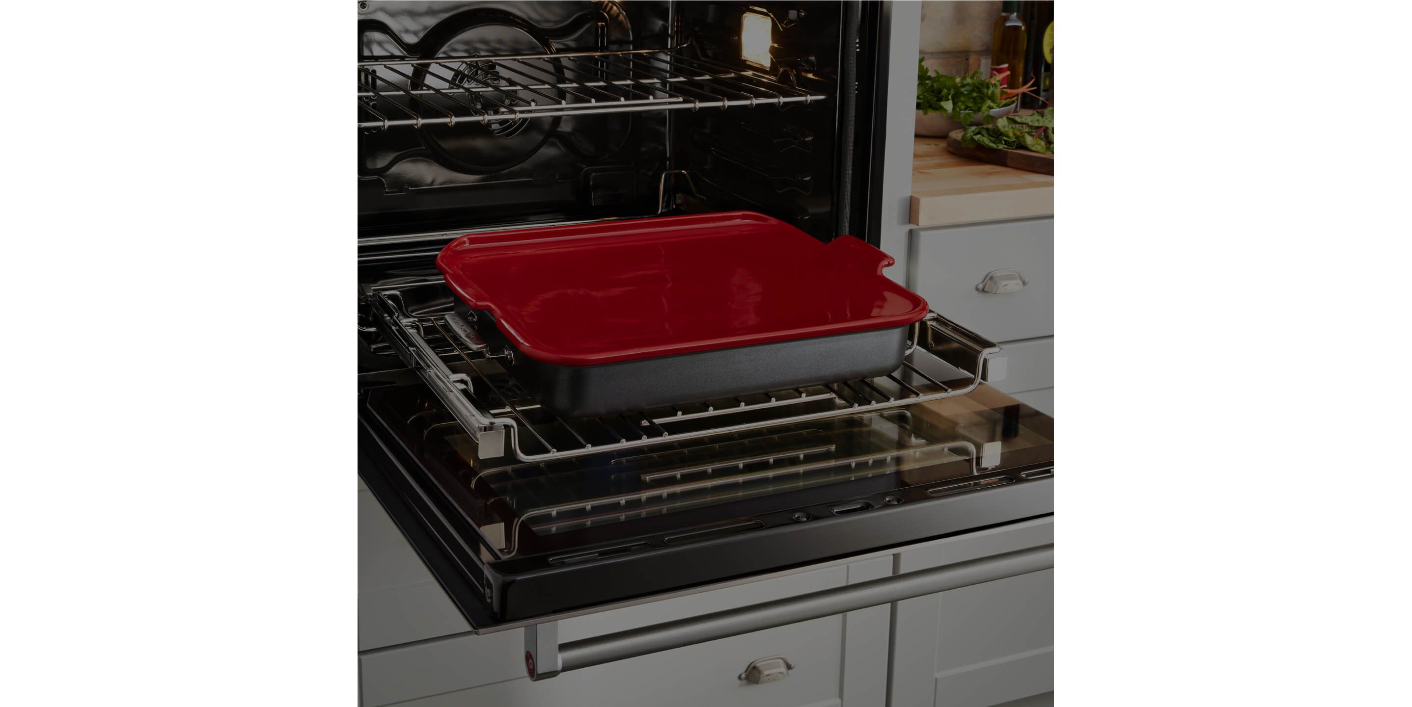 An open Smart Oven+ wall oven with a pan of carrots.