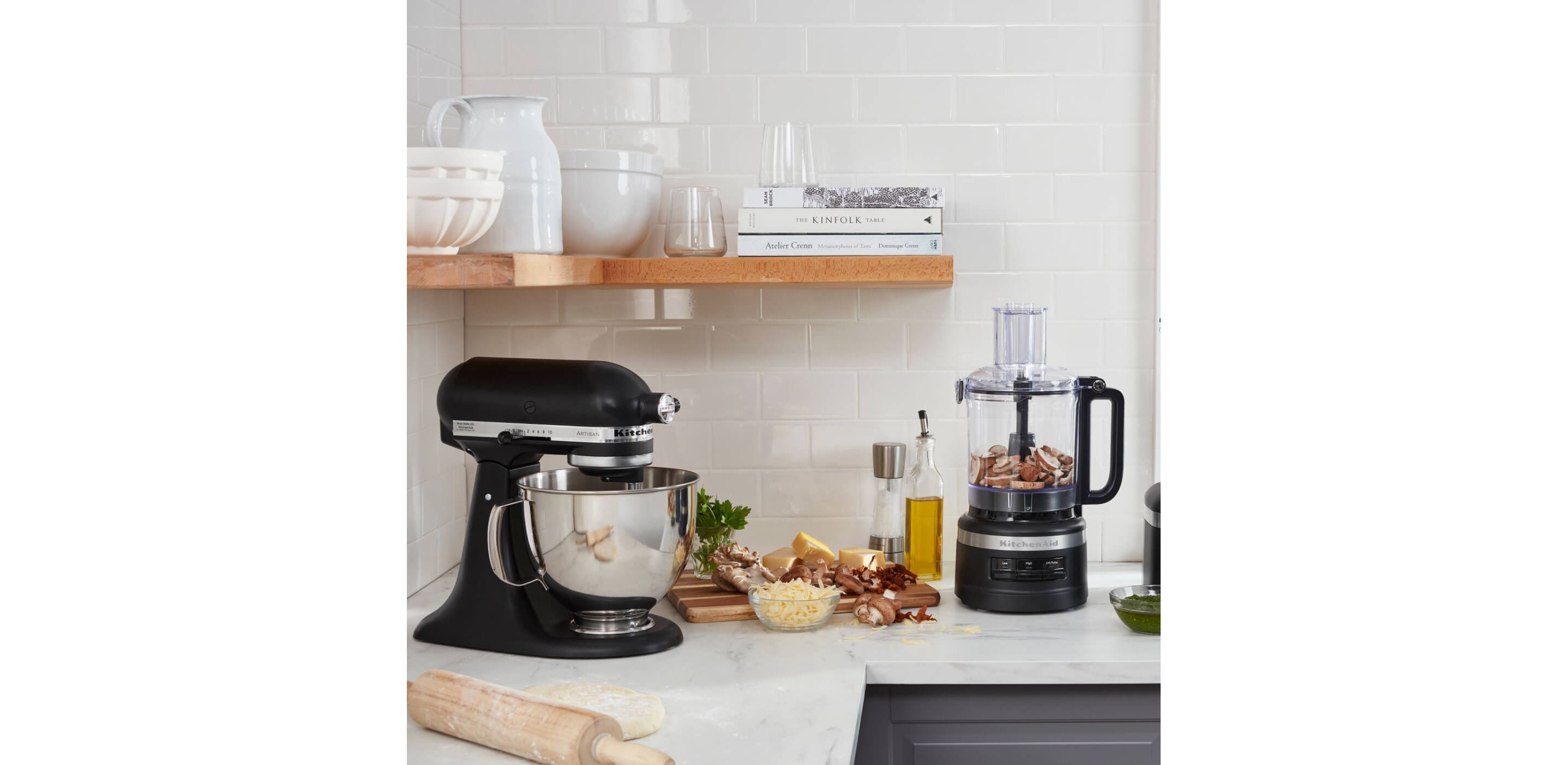 A KitchenAid® Stand Mixer and Food Processor in a crisp, stylish kitchen preparing fresh ingredients.