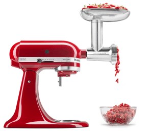 
                              Red stand mixer with grinder attachment grinding freshly-ground meat.
                          