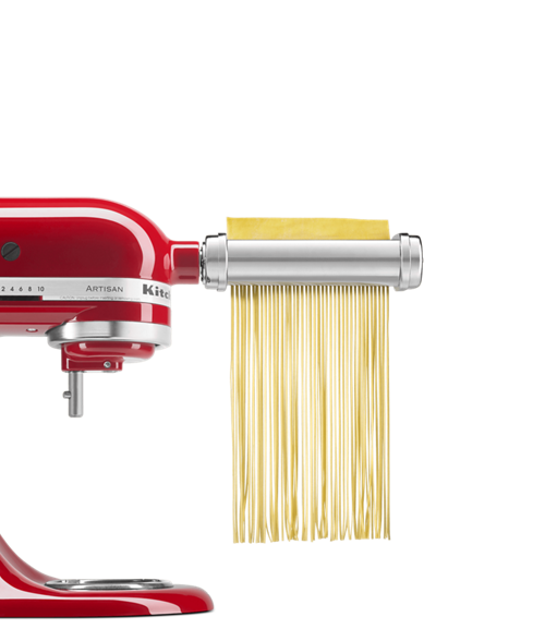 Batteur sur socle rouge avec accessoire pour
                    pâtes et graines taillant des feuilles de pâte
                    en bandes de linguine