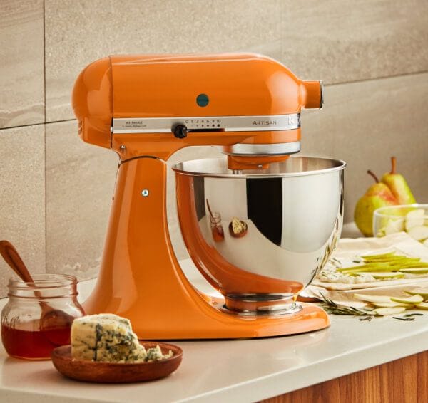 Honey KitchenAid® stand mixer on a counter with fruit, cheese and honey