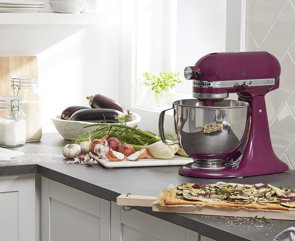 Boysenberry KitchenAid® stand mixer on a counter with eggplant, garlic and onion flatbread