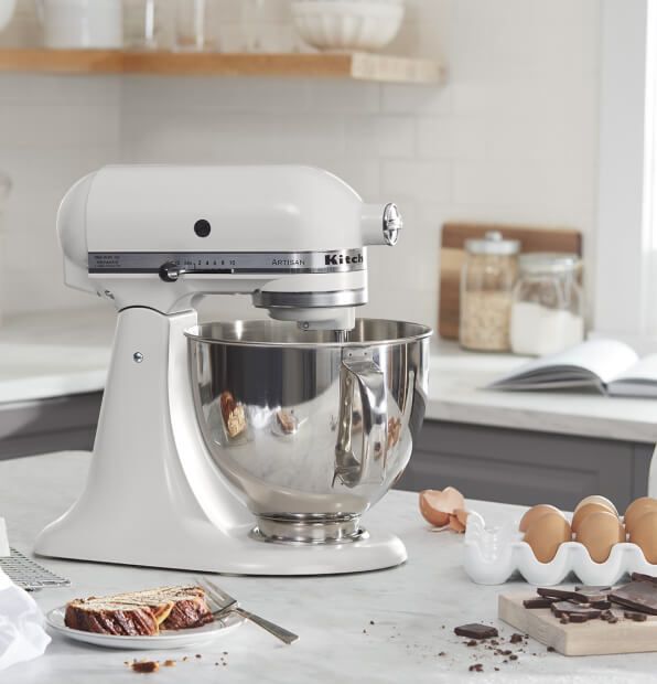 White KitchenAid® stand mixer on a counter with baking ingredients