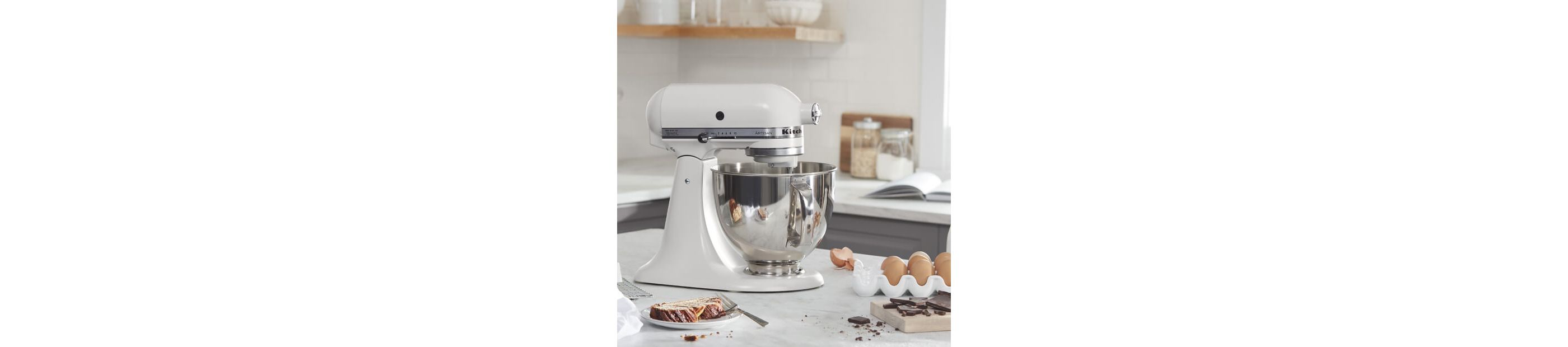 White KitchenAid® stand mixer on a counter with baking ingredients
