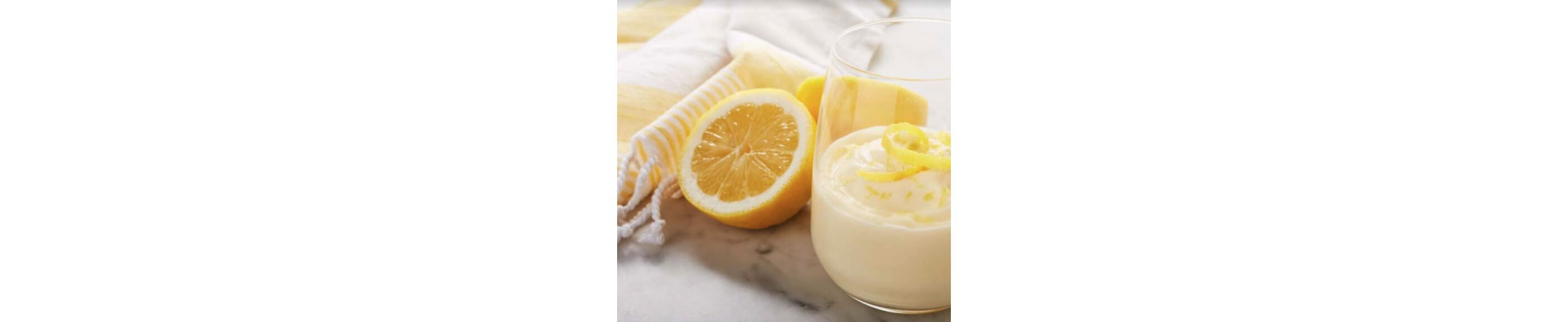 Lemon mousse in a glass next to half a lemon