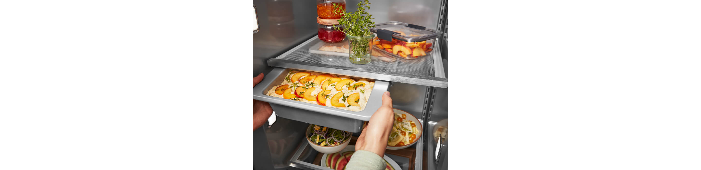 KitchenAid® Built-In Side-by-Side Refrigerator Under-Shelf Prep Zone holding a peach dessert  