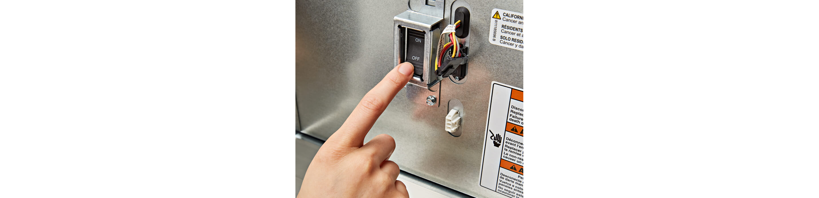 A person pressing the ON/OFF Power Switch on the KitchenAid® Built-In Side-by-Side Refrigerator