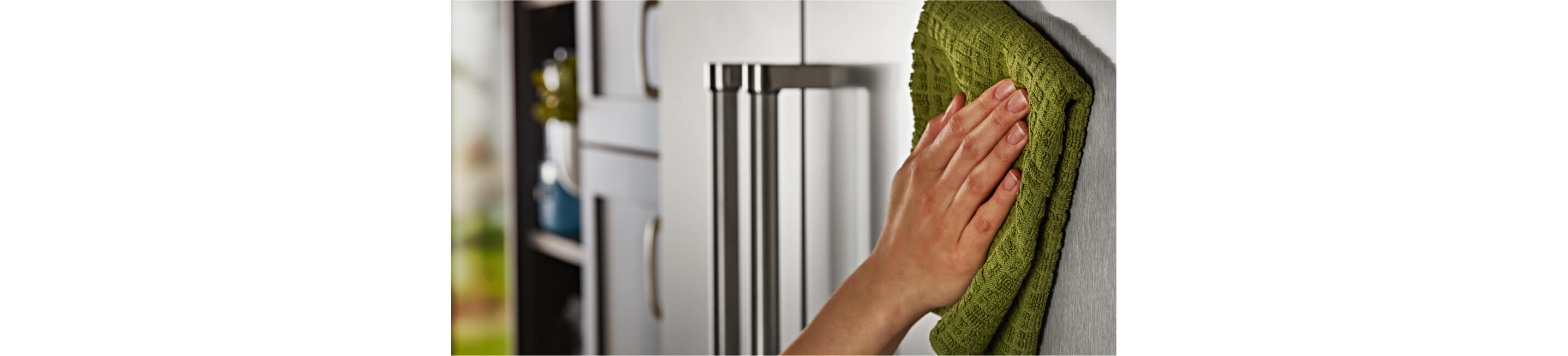 Cleaning exterior of a KitchenAid® Built-In Side-by-Side Refrigerator with microfiber cloth