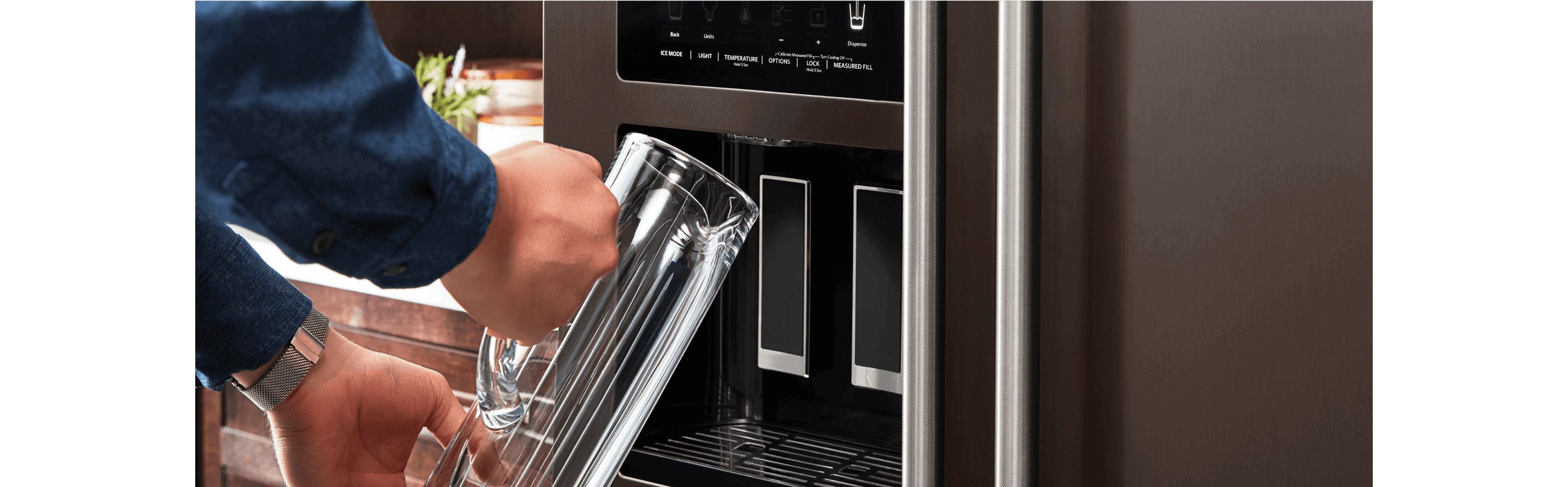 Filling a pitcher from a KitchenAid refrigerator water dispenser.