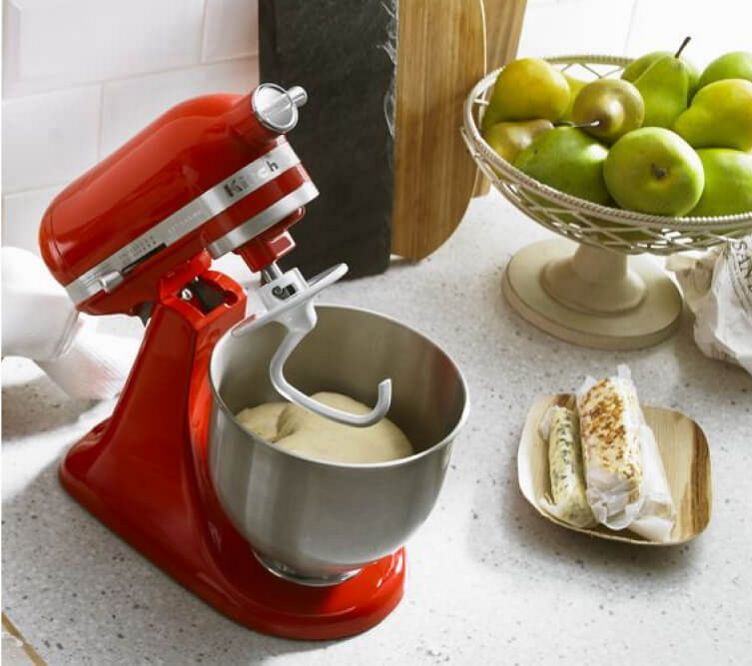 Red Stand Mixer with dough hook attached, and stainless steel bowl with dough in it.