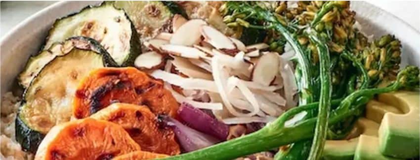 A cauliflower rice bowl topped with assorted vegetables.