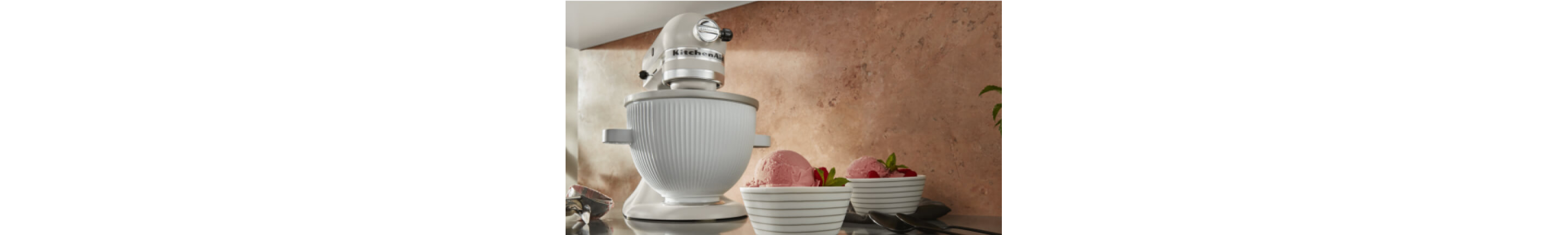 A KitchenAid® Stand Mixer using the ice cream maker attachment to make raspberry ice cream.