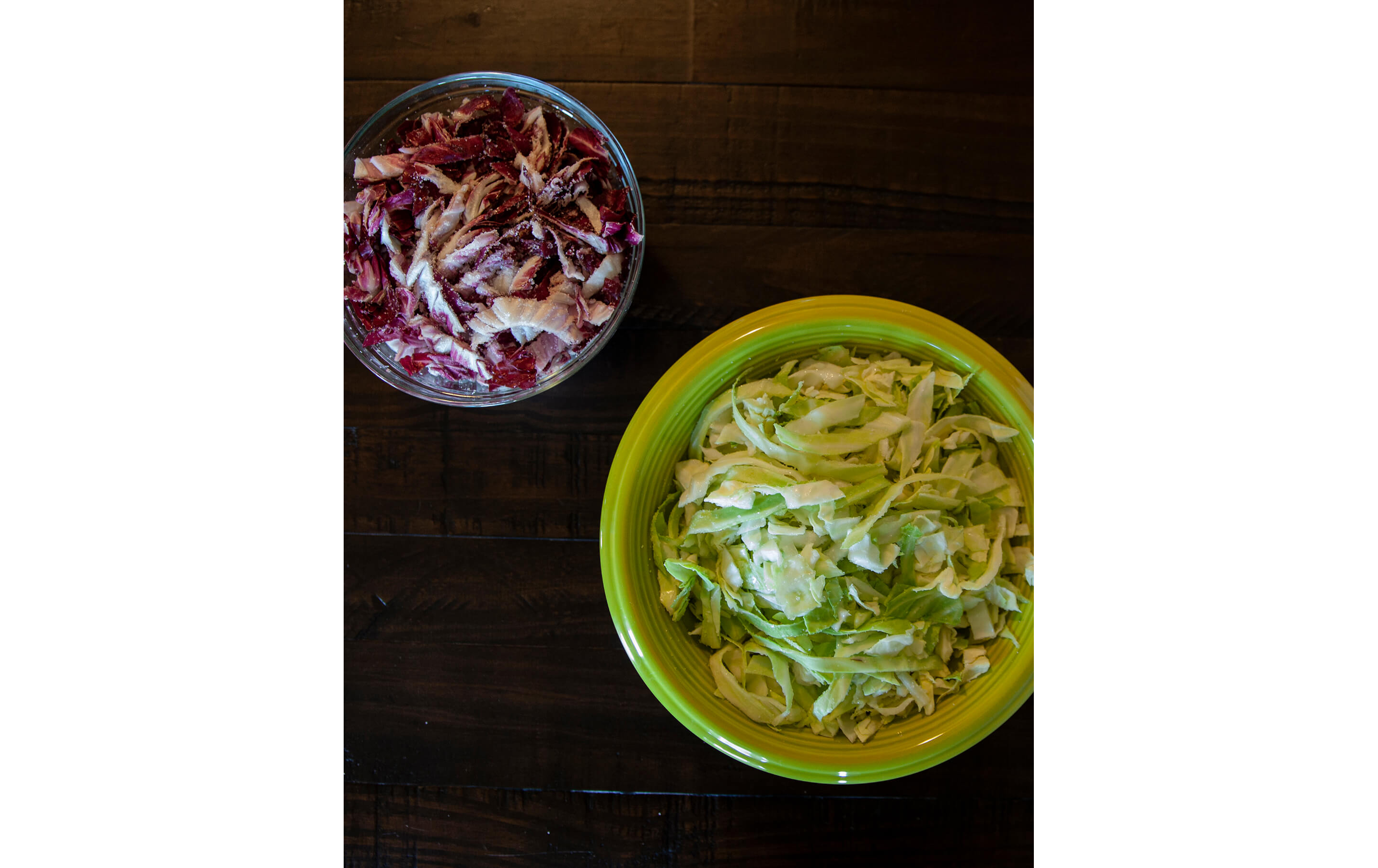 Chopped red and green cabbage resting in separate bowls.