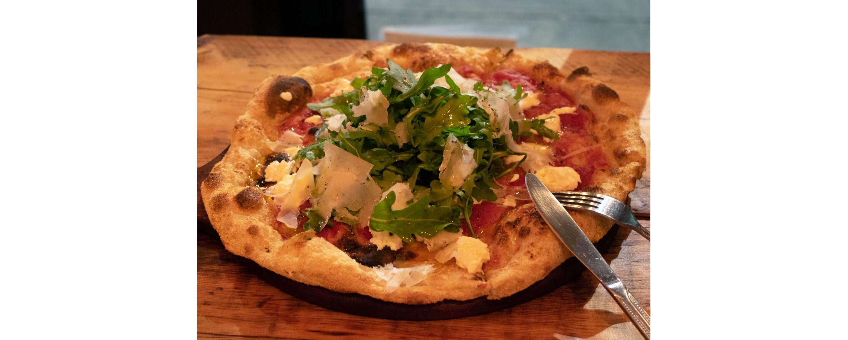 A fresh from the oven pizza presented on a wooden cutting board.