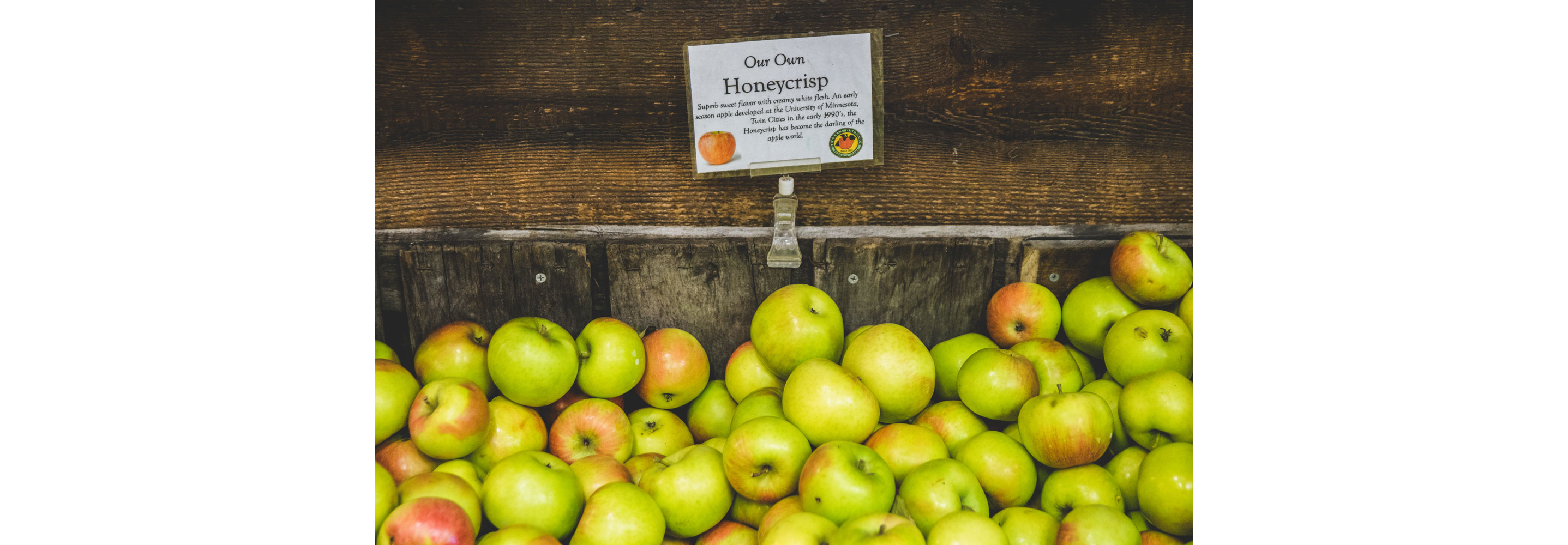 A wooden box filled with Honeycrisp apples.