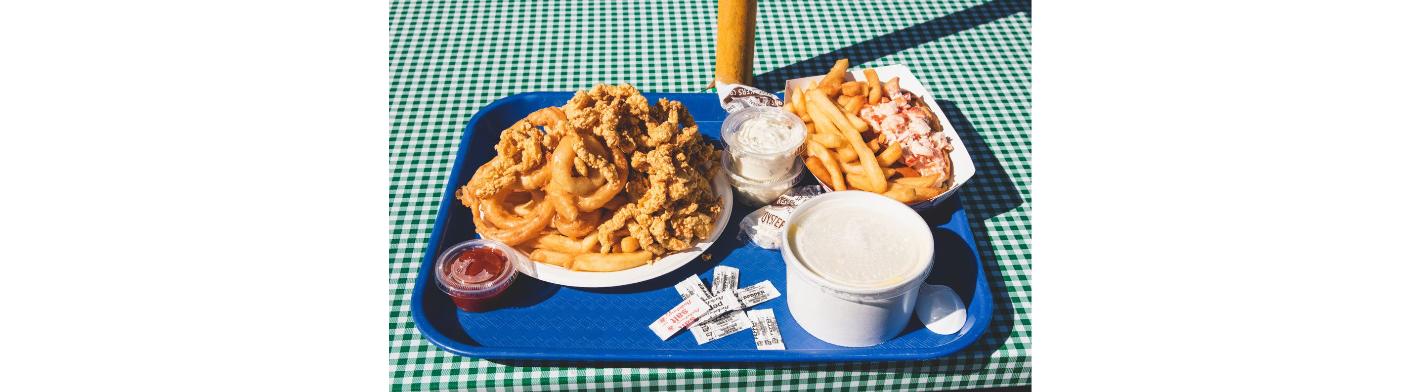 A tray filled with fried clams, french fries and other fried eats of Woodman's.