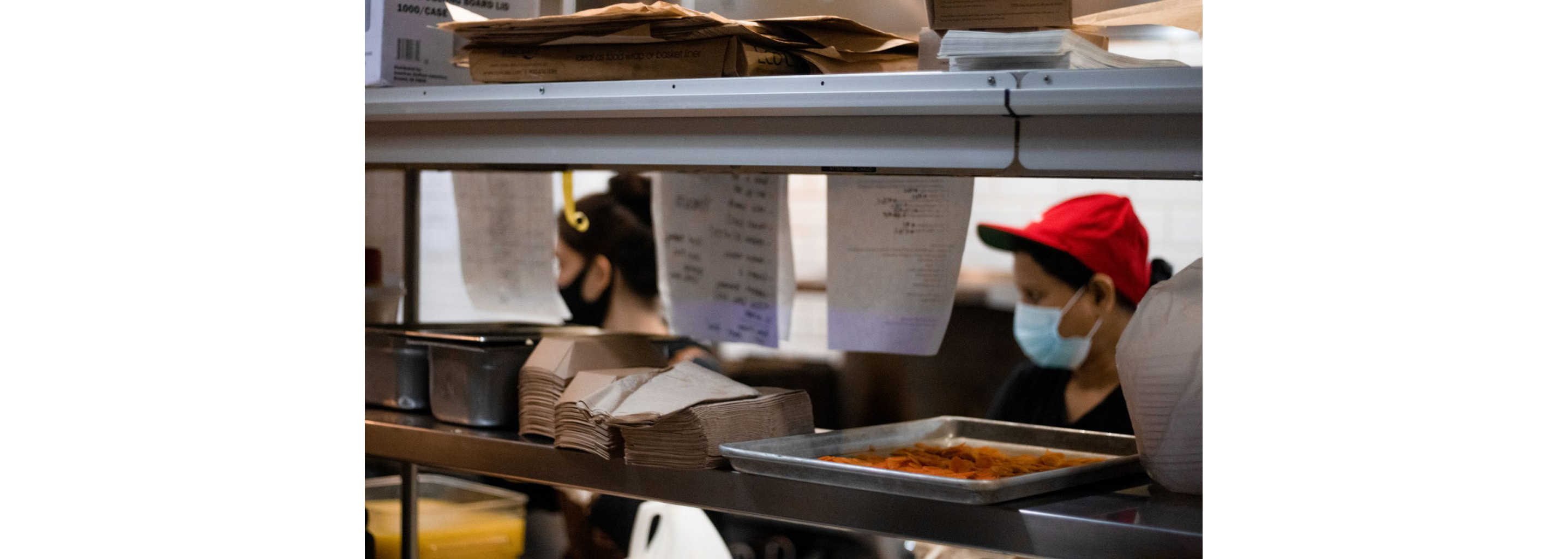 Kitchen order tickets strewn about for workers to fulfill.