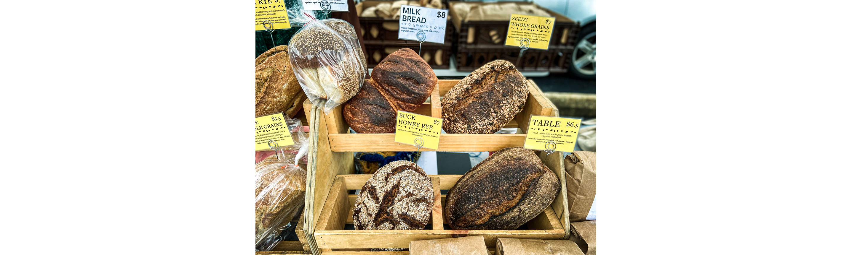 A small wooden stand filled with assorted baked bread.