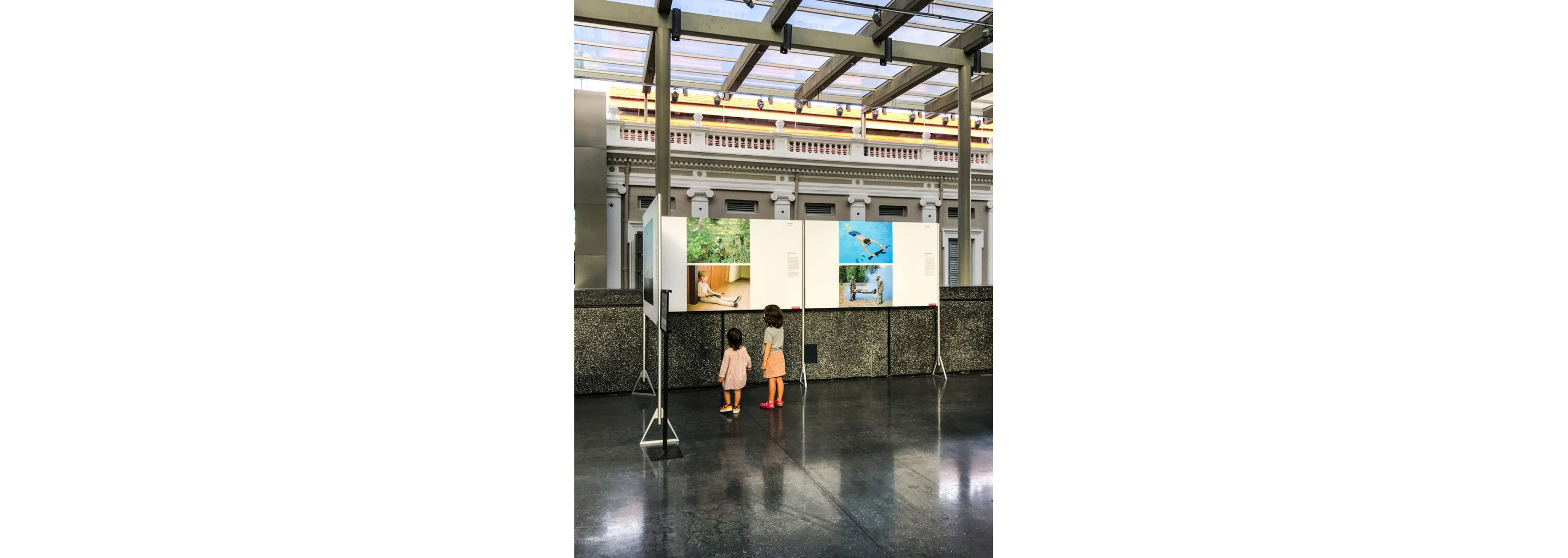 Two children looking at a photography exhibit in a museum.