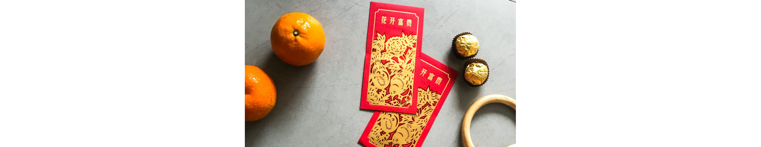 Lunar New Year cards on a table with oranges, candies and wooden hoop.