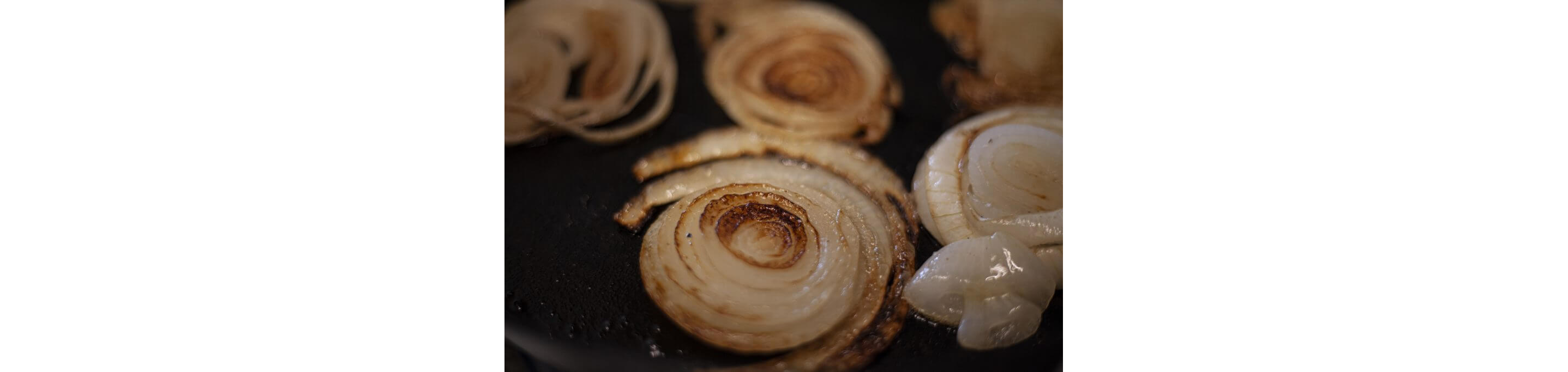 Sliced onions cooking in a skillet.