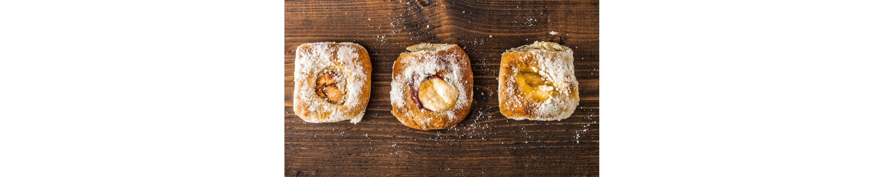 Kolaches topped with powdered sugar.