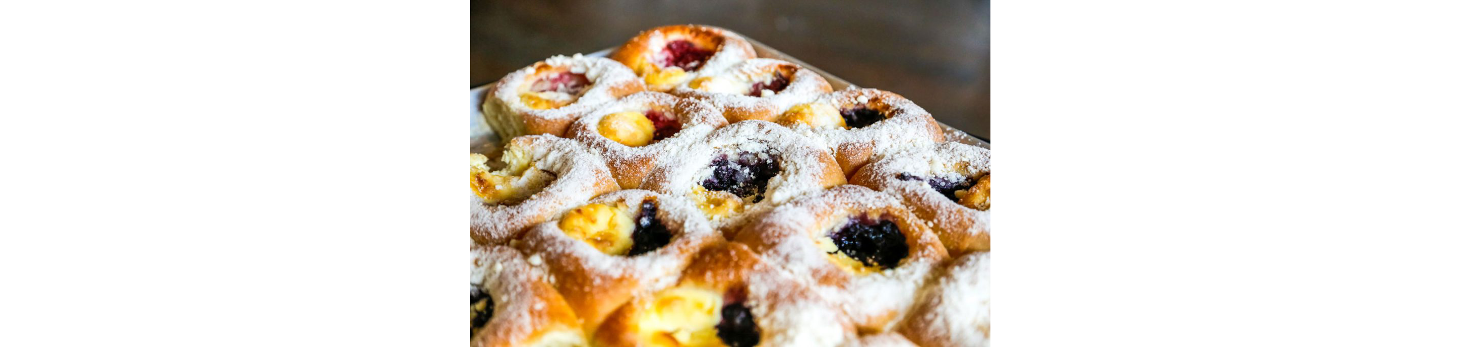 Kolaches topped with powdered sugar.