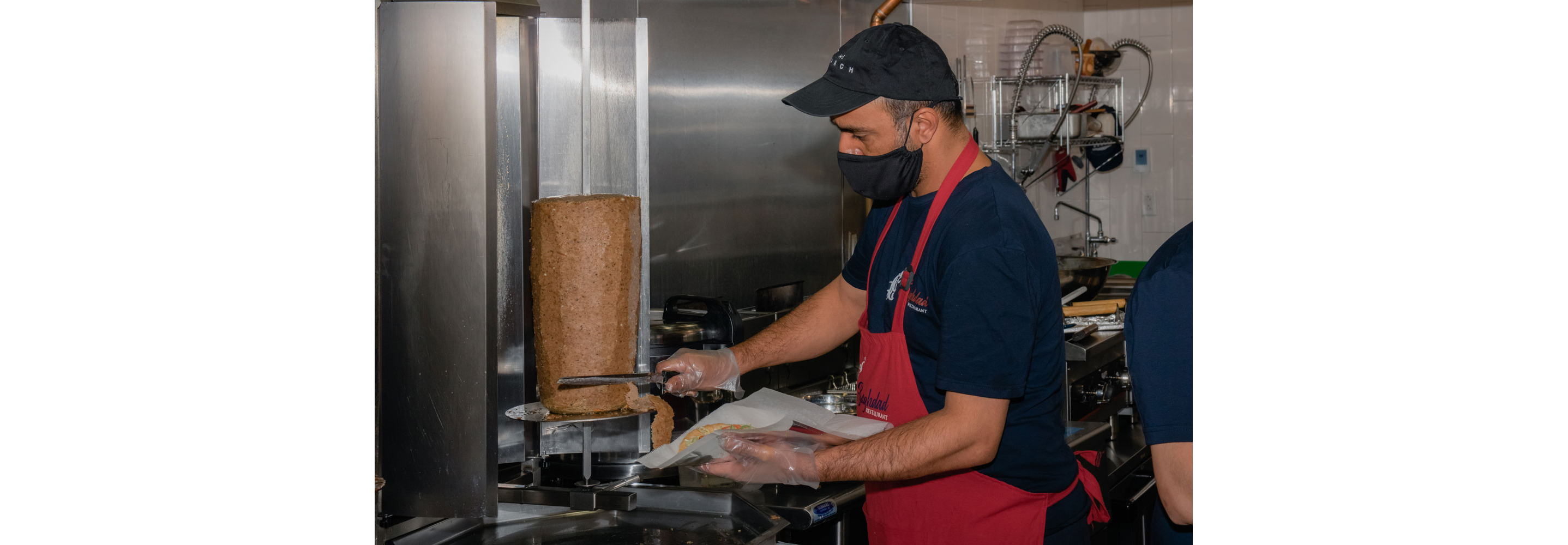 Firas trimming meat for a gyro.