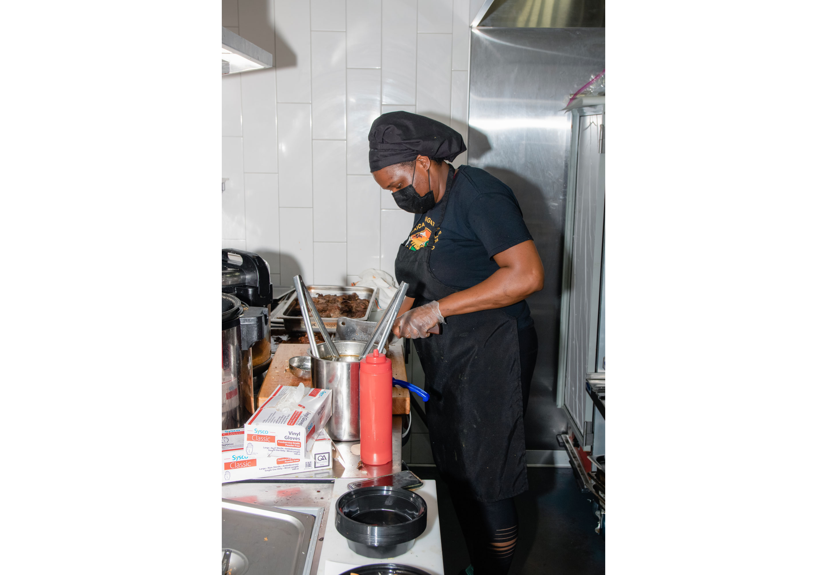 Latoya chopping meat in her kitchen.